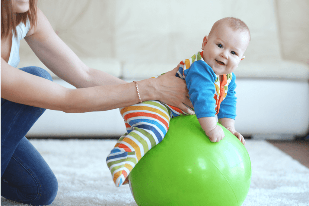 smiling baby placed on a green ball living room setting